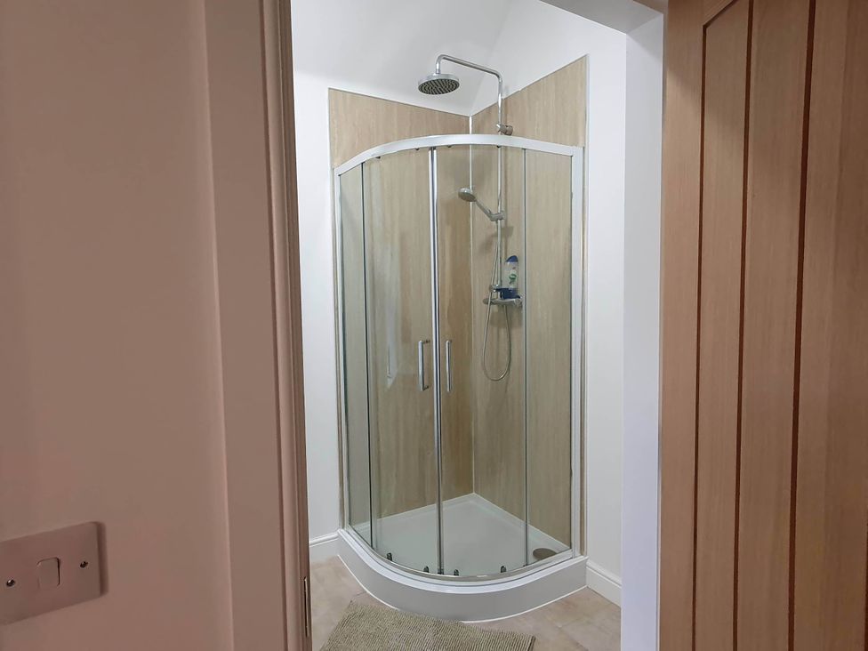 A shower with glass doors and wall in a bathroom at 2-Bed Barn, Hot Tub & Pet Friendly near Muirkirk