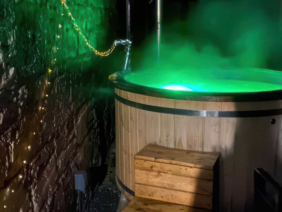 A hot tub with steam and green lighting at 2-Bed Barn, Hot Tub & Pet Friendly near Muirkirk