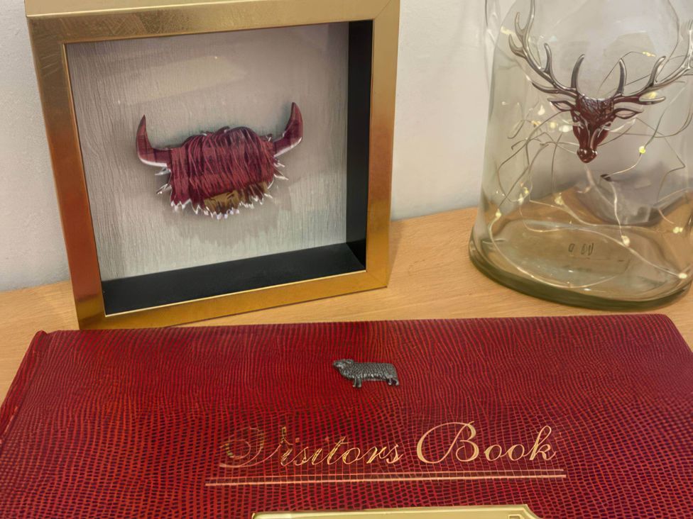 A framed art piece, a glass cloche and a visitors book at 2-Bed Barn, Hot Tub & Pet Friendly near Muirkirk
