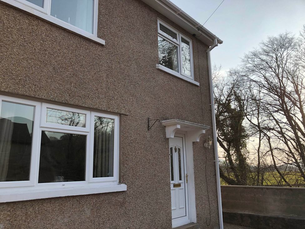 A house exterior with windows and a door at 3 Bed House - Sleeps 6 - Parking - Garden - Wifi Glynneath