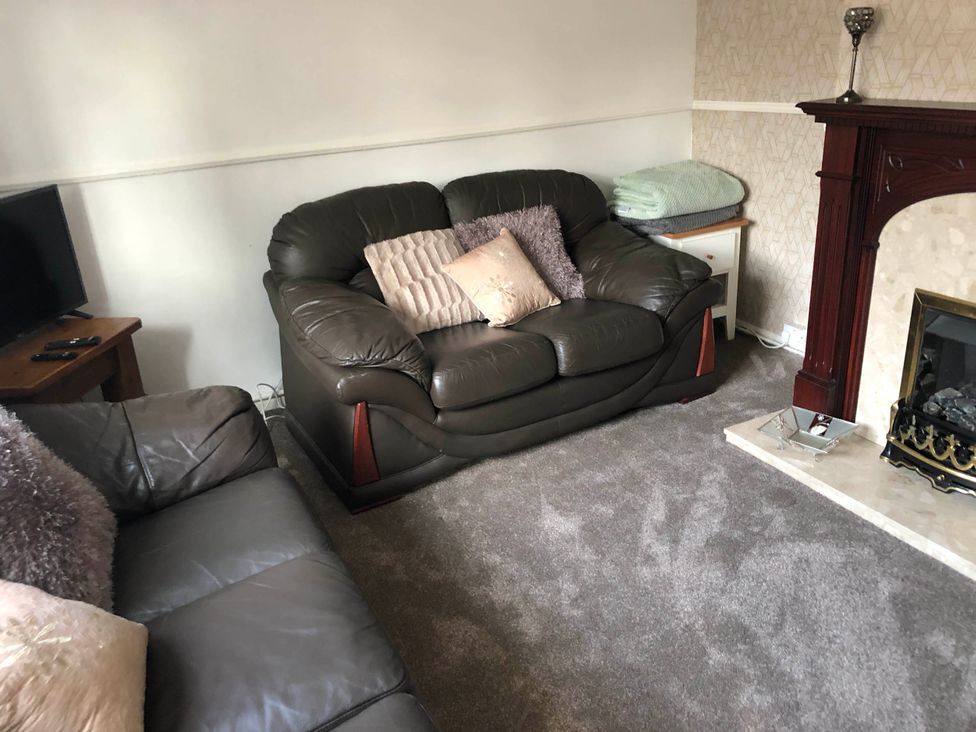 A living room with a sofa and television at 3 Bed House - Sleeps 6 - Parking - Garden - Wifi Glynneath