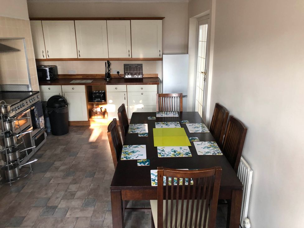 A kitchen with a dining table and chairs at 3 Bed House - Sleeps 6 - Parking - Garden - Wifi Glynneath