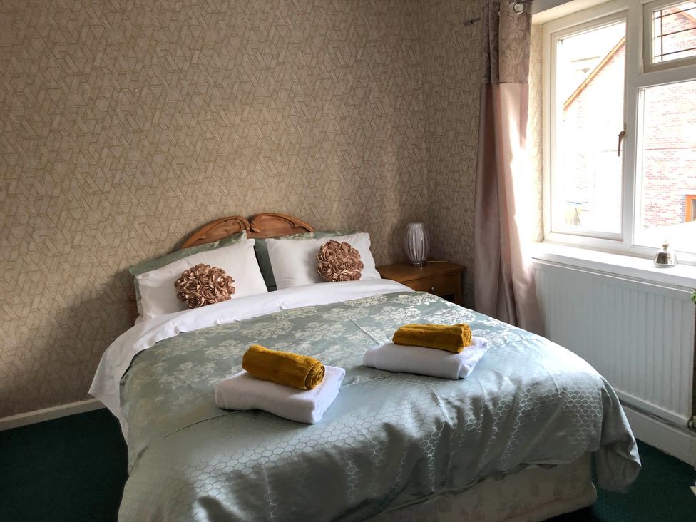A bedroom with a bed and towels at 3 Bed House - Sleeps 6 - Parking - Garden - Wifi Glynneath