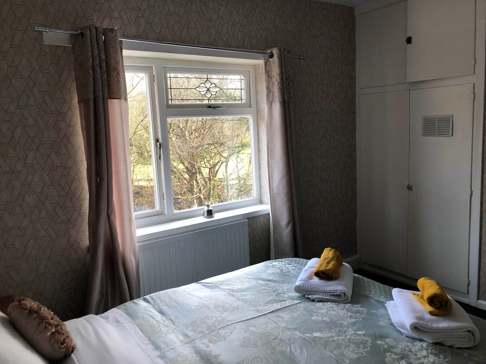 A bedroom with a bed and window at 3 Bed House - Sleeps 6 - Parking - Garden - WIfi Glynneath