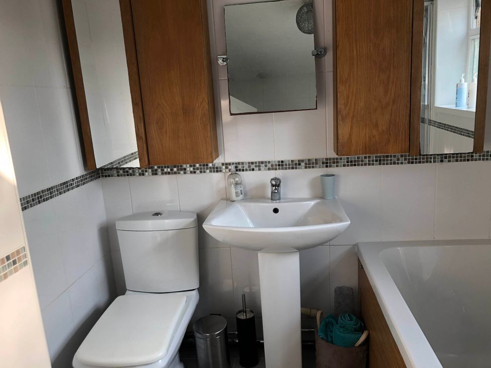 A bathroom with a toilet, sink, and bath tub at 3 Bed House - Sleeps 6 - Parking - Garden - Wifi Glynneath