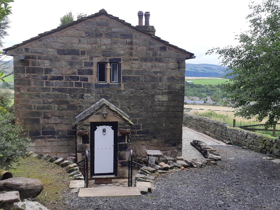 An outdoor view of a stone building with stairs and a doorway at 3 bedroom- Sleeps 6-Greave Farm Todmorden Cottage, Todmorden