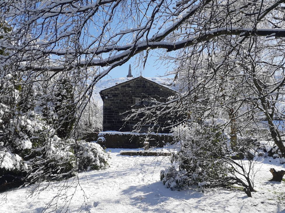 A building surrounded by snow and trees at 3 bedroom- Sleeps 6-Greave Farm Todmorden Cottage, Todmorden