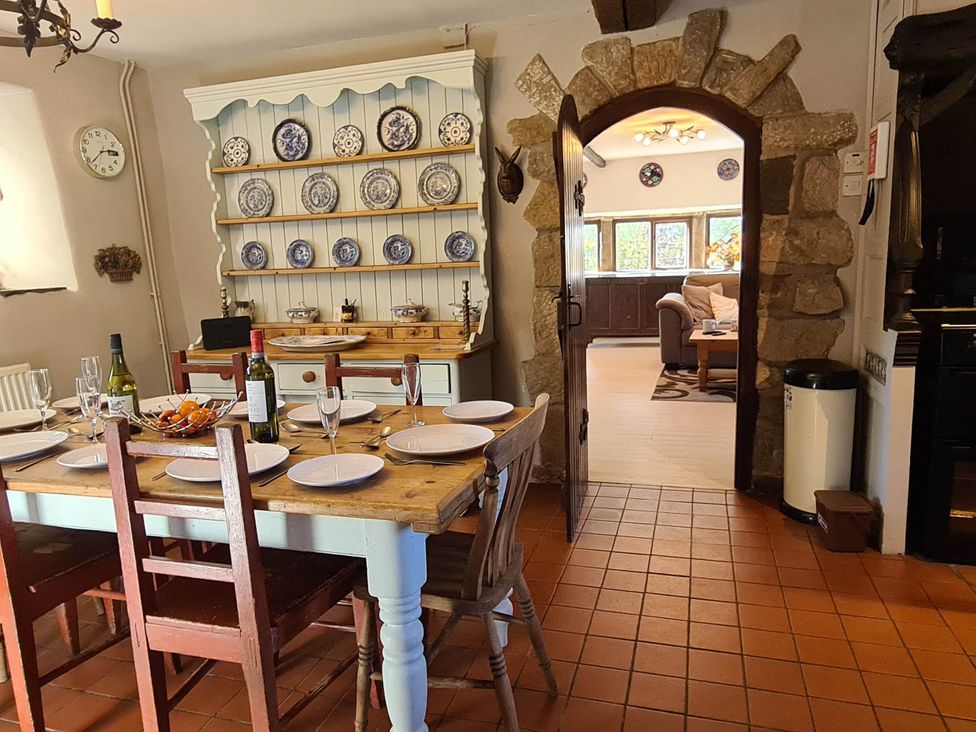 A kitchen with a dining table and plates displayed at 3 bedroom- Sleeps 6-Greave Farm Todmorden Cottage in Todmorden