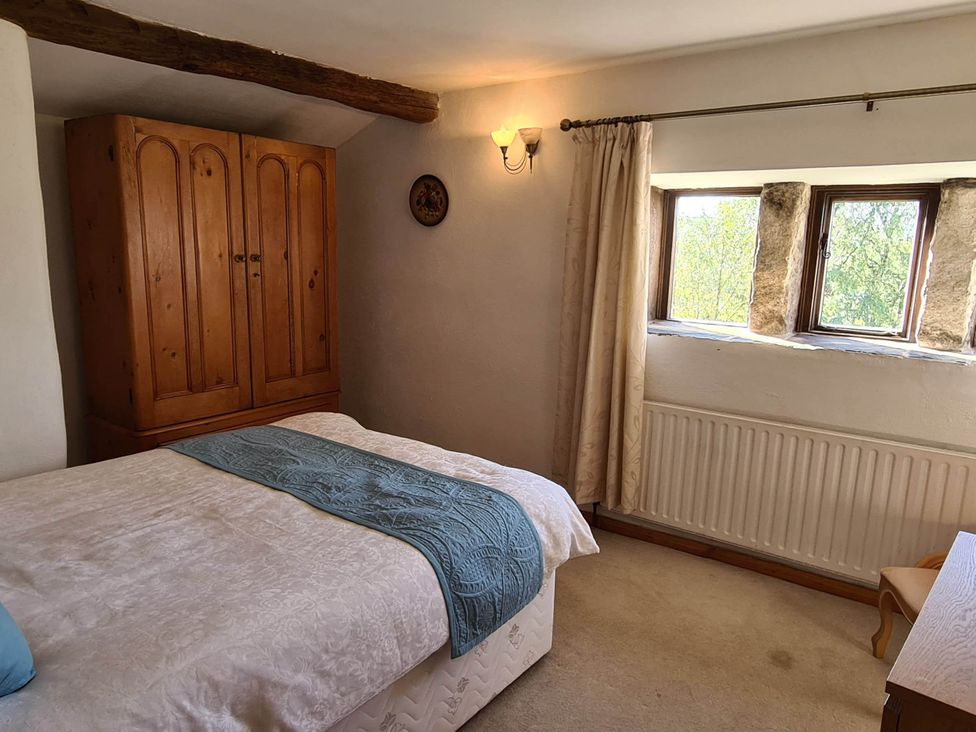A bedroom with a bed and wardrobe at 3 bedroom- Sleeps 6-Greave Farm Todmorden Cottage, Todmorden