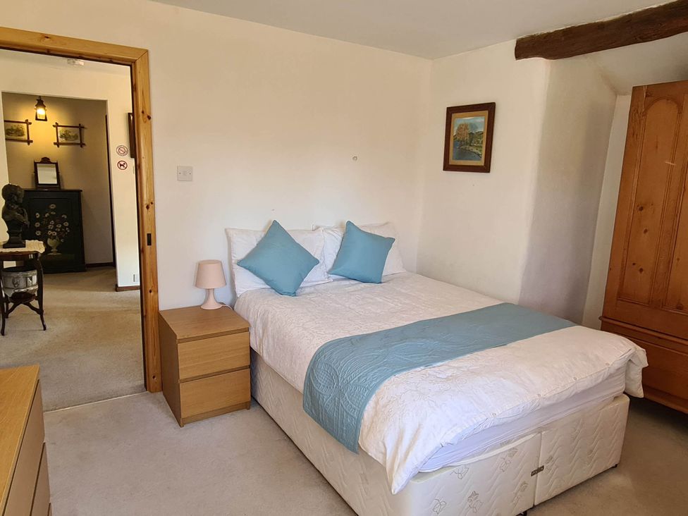 A bedroom with a bed and nightstand at 3 bedroom- Sleeps 6-Greave Farm Todmorden Cottage in Todmorden