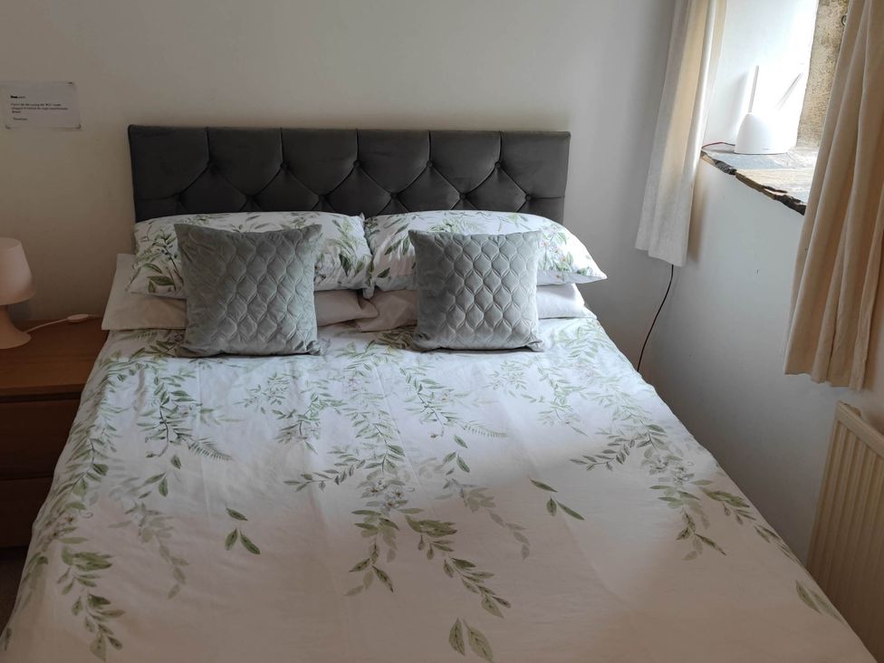 A bedroom with a bed and bedside lamp at 3 bedroom- Sleeps 6-Greave Farm Todmorden Cottage Todmorden