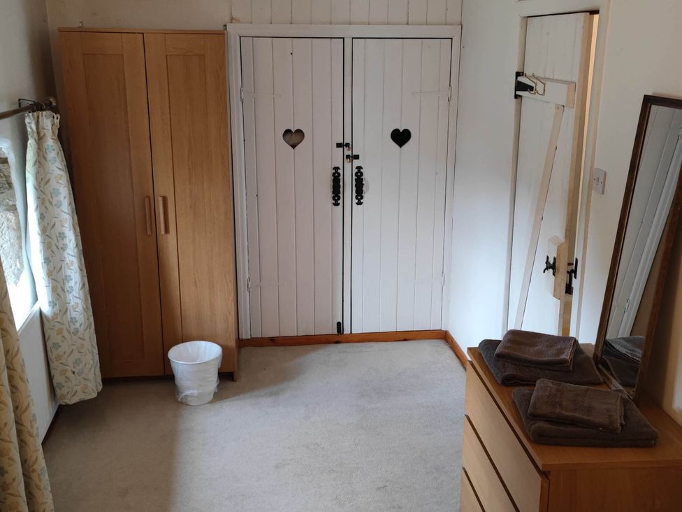 A bedroom with a wardrobe and mirror at 3 bedroom- Sleeps 6-Greave Farm Todmorden Cottage Todmorden
