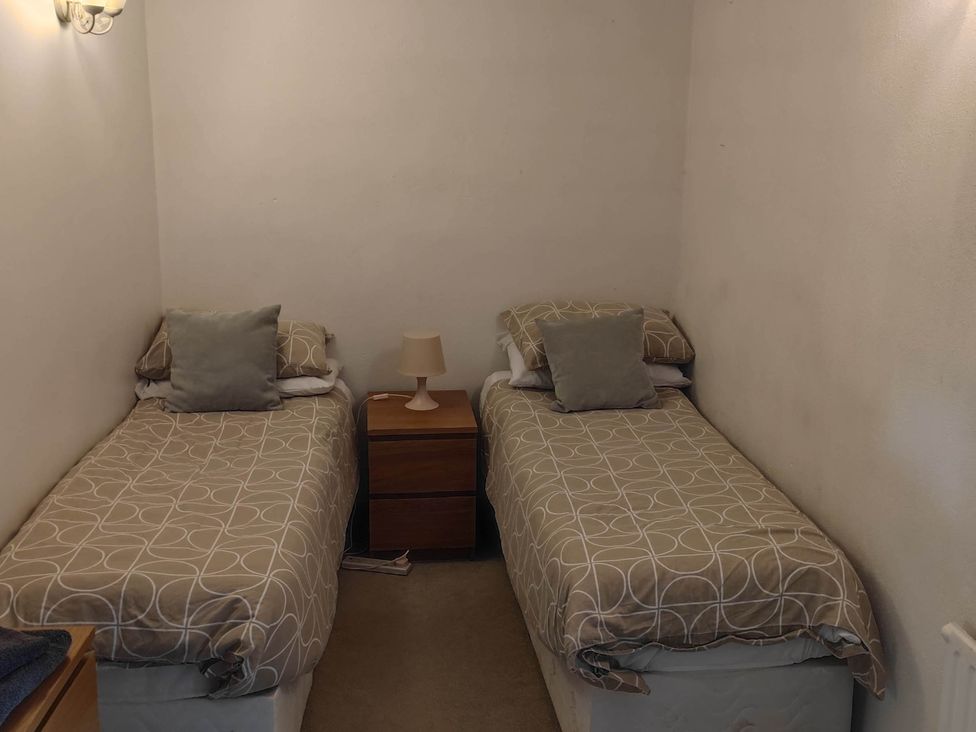 A bedroom with two single beds and a nightstand at 3 bedroom- Sleeps 6-Greave Farm Todmorden Cottage in Todmorden