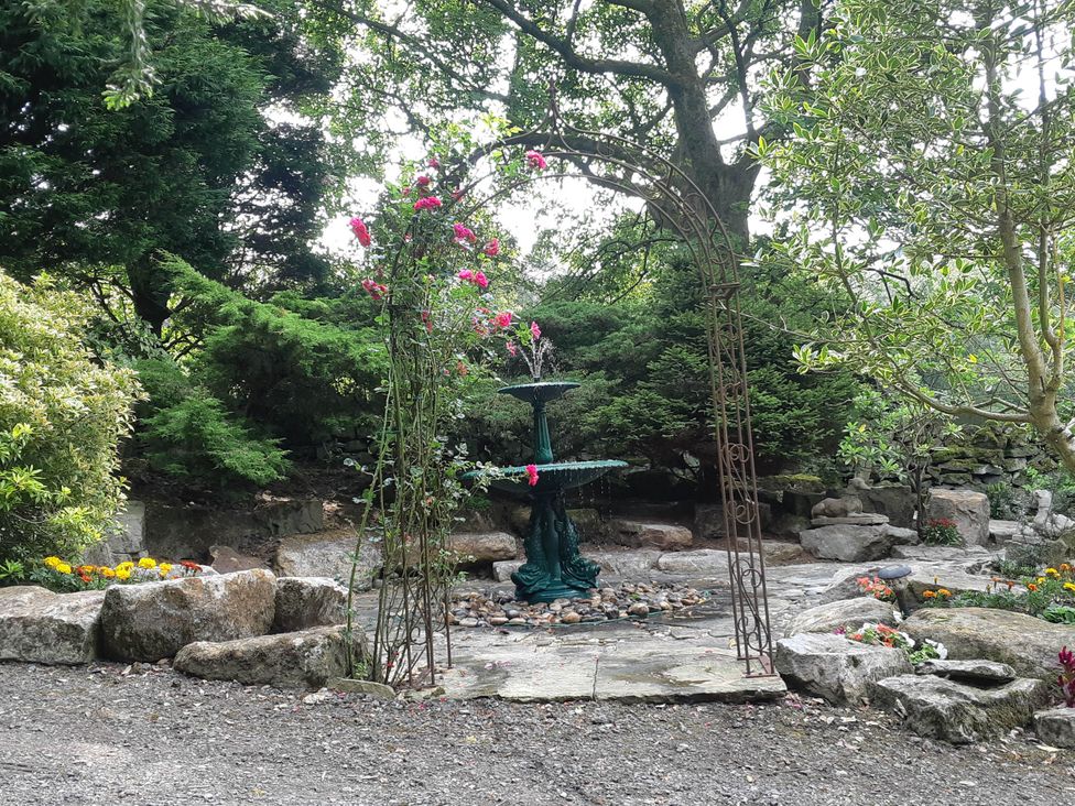 A garden with a fountain and flowers at 3 bedroom- Sleeps 6-Greave Farm Todmorden Cottage Todmorden