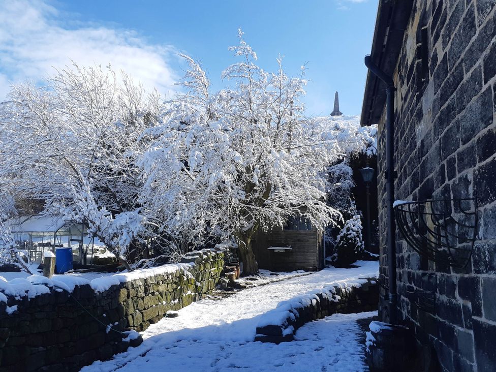 An outdoor area with snow-covered trees and a stone path at 3 bedroom- Sleeps 6-Greave Farm Todmorden Cottage, Todmorden
