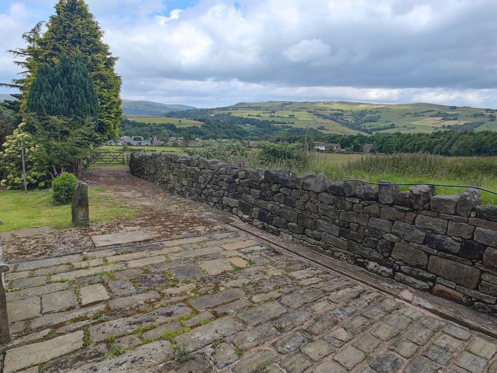 An outdoor area with a paved path and stone wall at 3 bedroom- Sleeps 6-Greave Farm Todmorden Cottage Todmorden