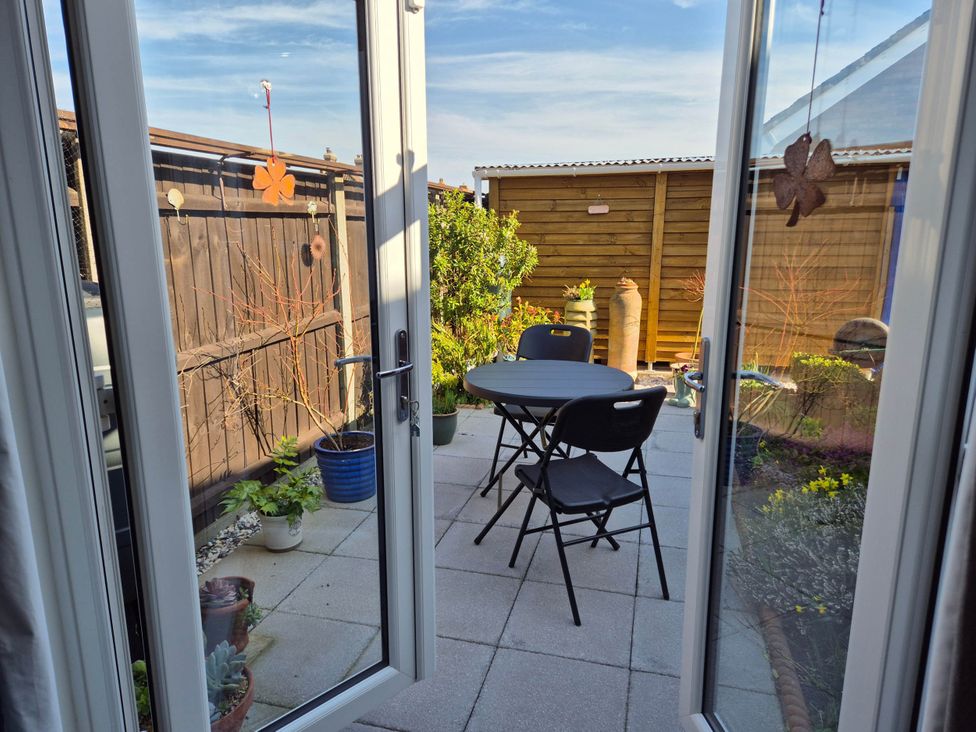 A garden with a folding table and chairs at Flower Garden Studio in Sheringham