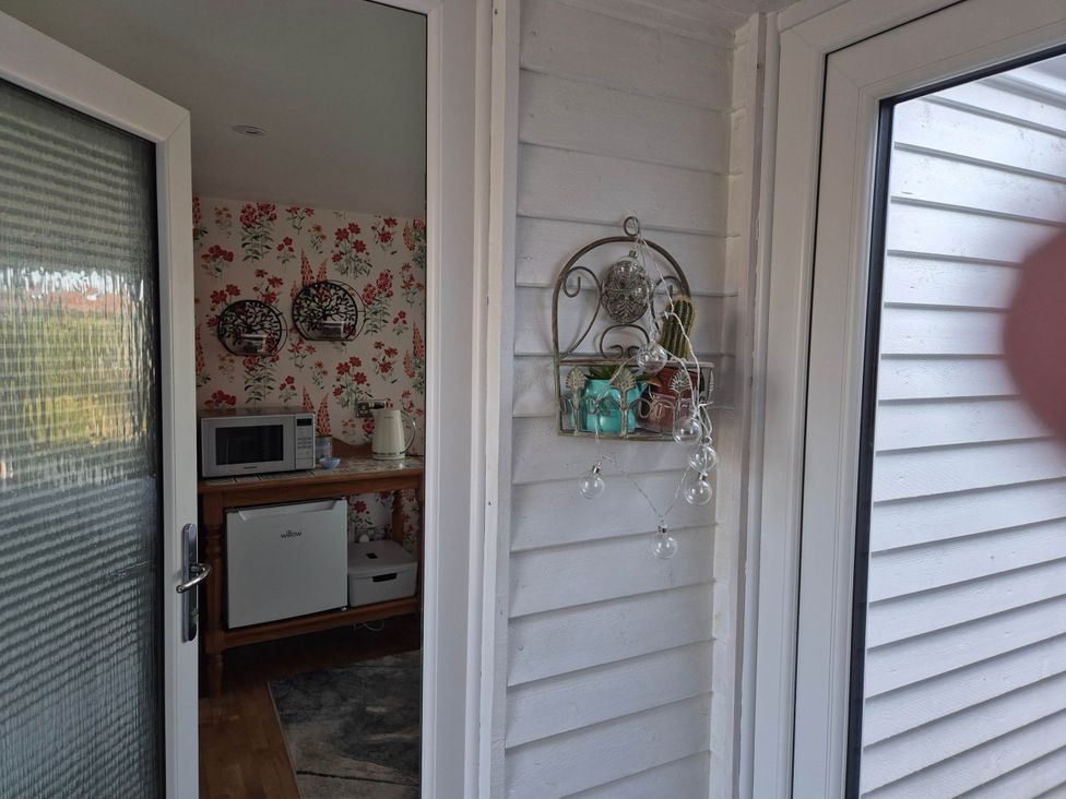 A kitchen with a microwave and kettle at Flower Garden Studio in Sheringham