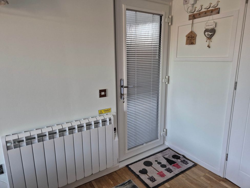 An entrance space with a door and a radiator at Flower Garden Studio in Sheringham