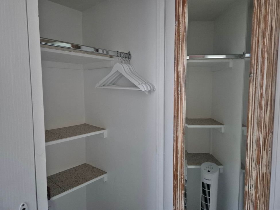 A closet with shelves and hangers at Flower Garden Studio in Sheringham