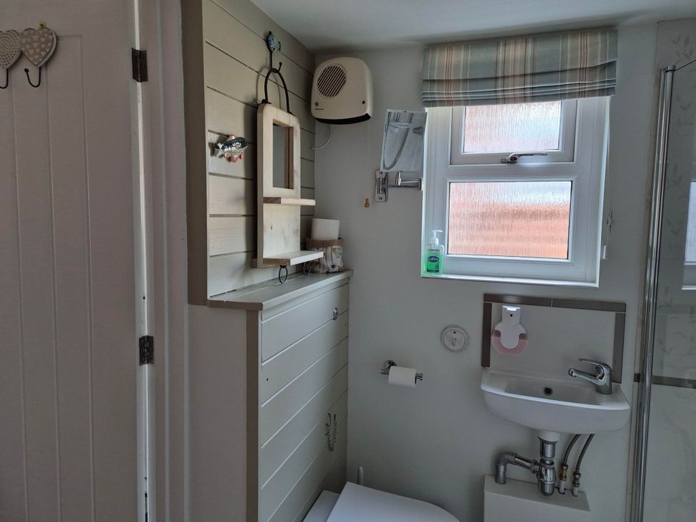 A bathroom with a sink and toilet at Flower Garden Studio in Sheringham