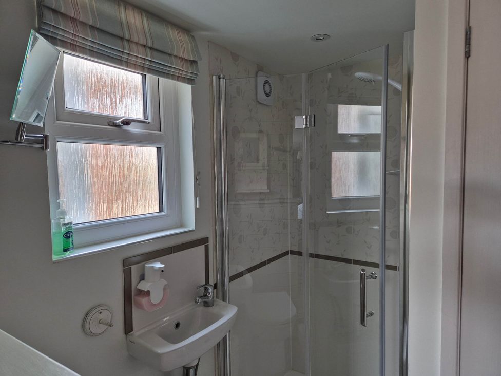 A bathroom with a sink and shower at Flower Garden Studio in Sheringham