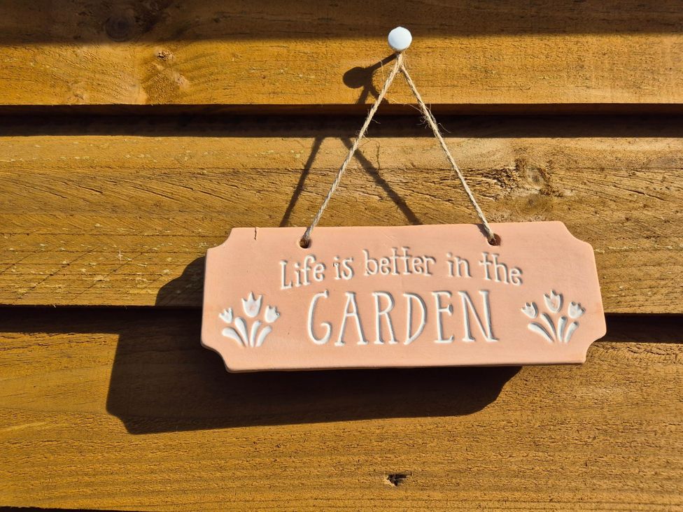A sign hanging that states Life is better in the GARDEN at Flower Garden Studio in Sheringham