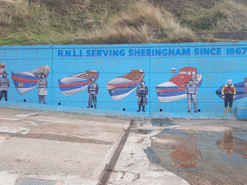 A mural depicting boats and figures at Flower Garden Studio in Sheringham