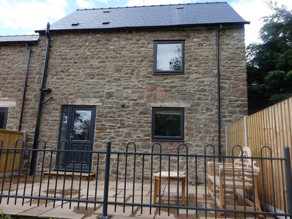 A stone building with windows and a doorway in an outdoor area at Cottage - Sleeps 2 - Garden in Coleford