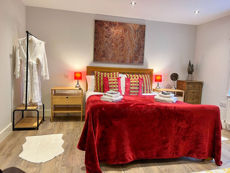 A bedroom with a bed and decorative pillows at Cottage - Sleeps 2 - Garden in Coleford