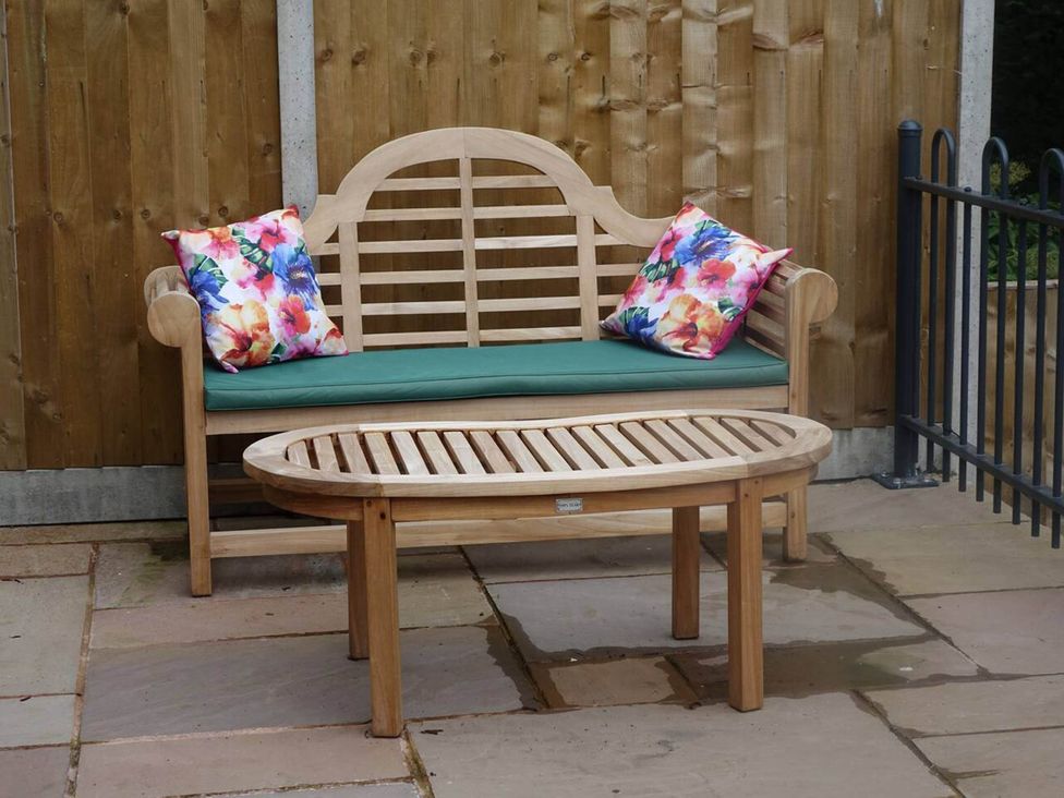 A garden with a wooden bench and a table at Cottage - Sleeps 2 - Garden in Coleford