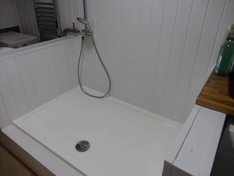 A shower with a showerhead and drain at Cottage - Sleeps 2 - Garden in Coleford