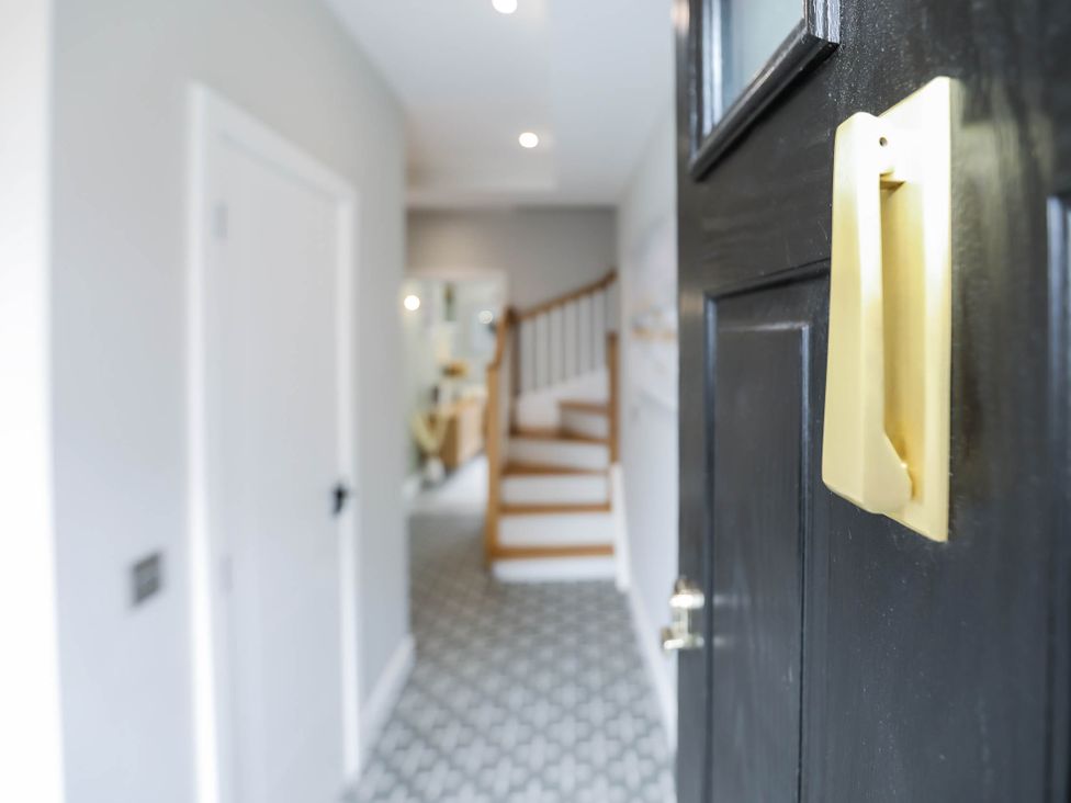 A hallway with a front door and stairs at Luxury 2 Bed Home w/ Spa-like Ensuites & Patio Hereford