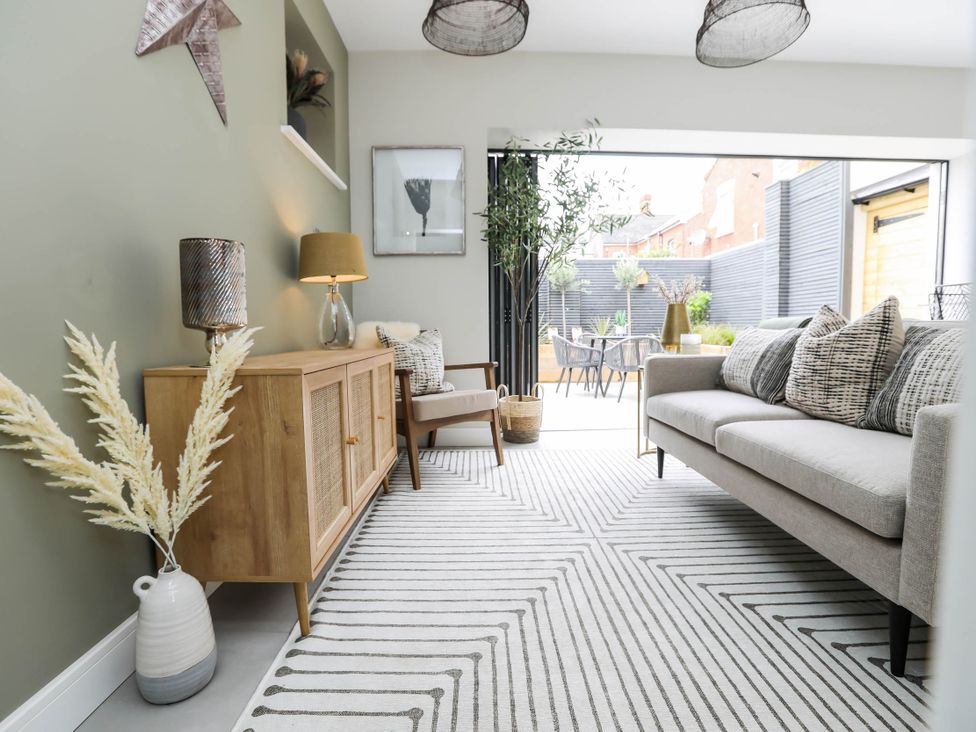 A living room with a sofa and storage cabinet at Luxury 2 Bed Home w/ Spa-like Ensuites & Patio in Hereford