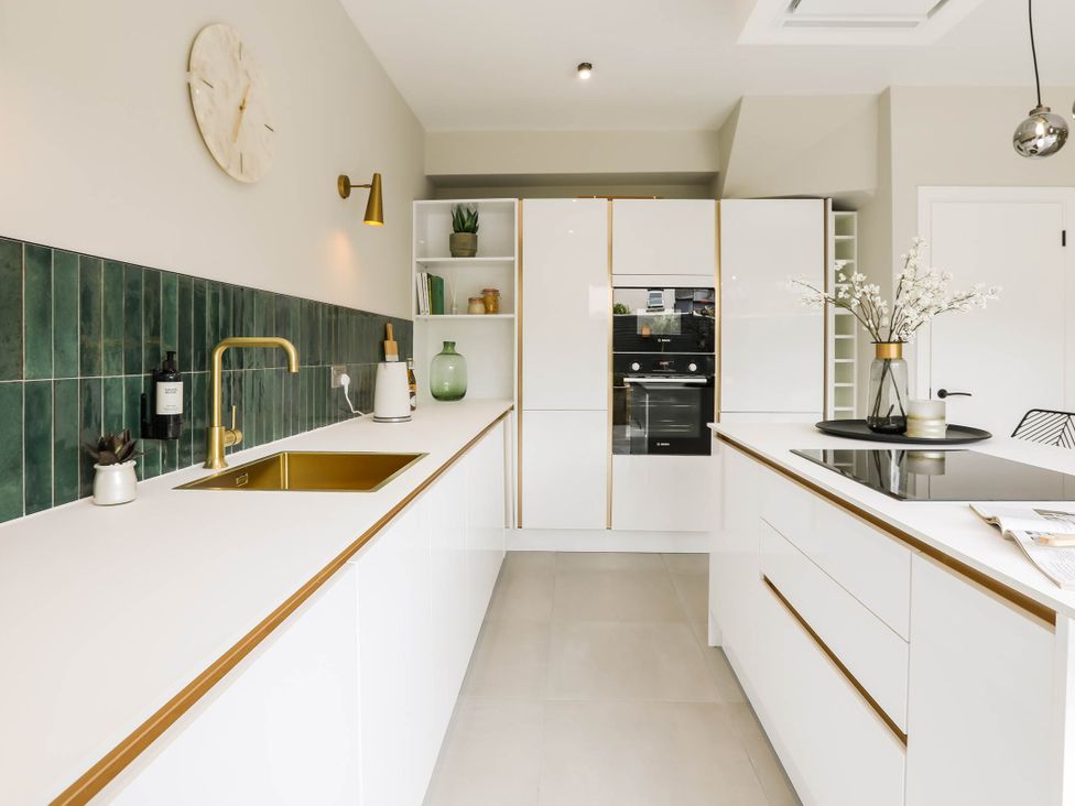 A kitchen with a sink, cabinets and appliances at Luxury 2 Bed Home w/ Spa-like Ensuites & Patio Hereford