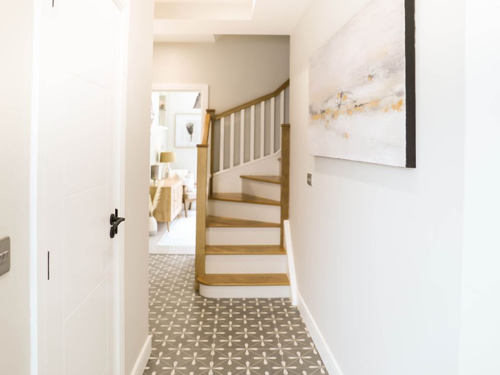 A hallway with a staircase and a door at Luxury 2 Bed Home w/ Spa-like Ensuites & Patio Hereford