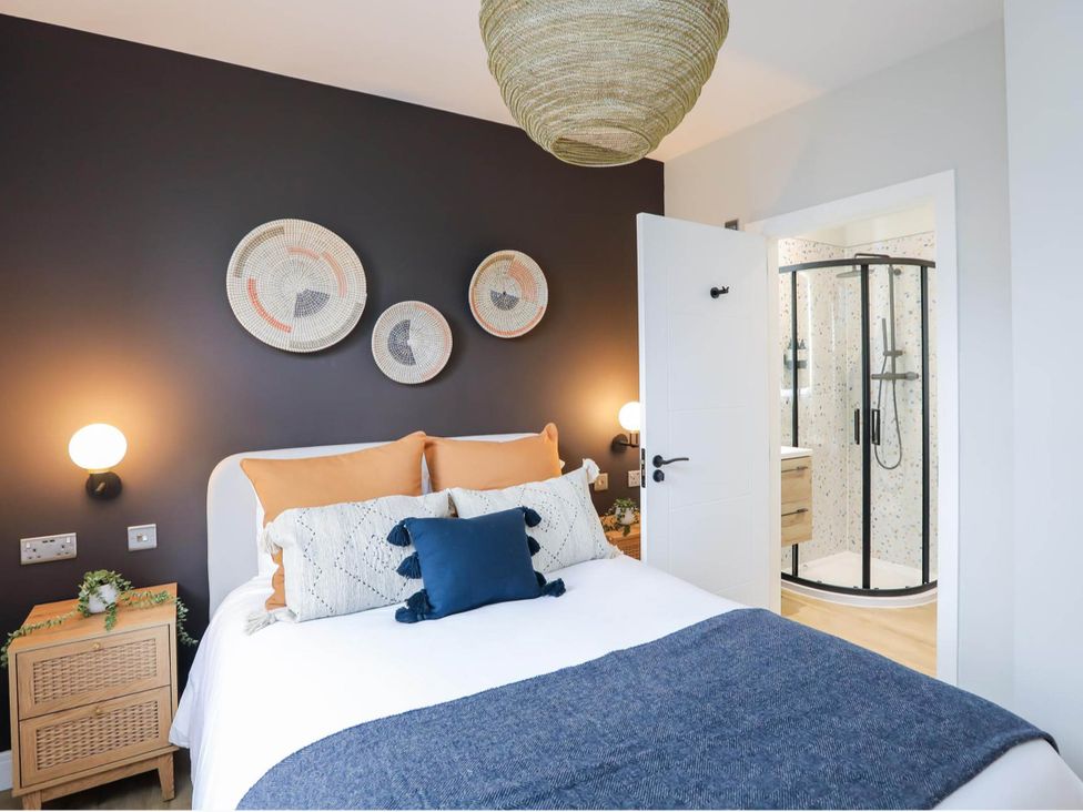 A bedroom with a bed and shower in Luxury 2 Bed Home w/ Spa-like Ensuites & Patio Hereford