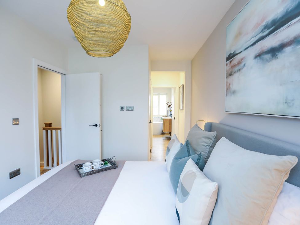 A bedroom with a bed and bedroom furniture at Luxury 2 Bed Home w/ Spa-like Ensuites & Patio, Hereford