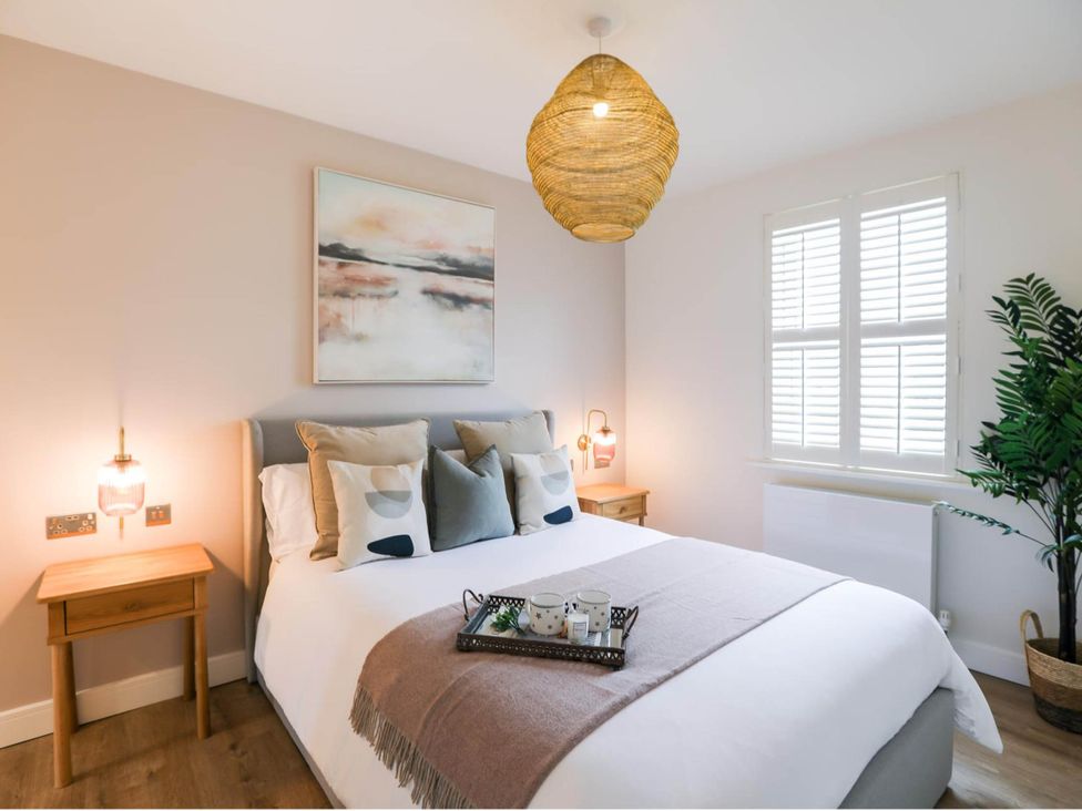 A bedroom with a bed and bedside tables at Luxury 2 Bed Home w/ Spa-like Ensuites & Patio Hereford