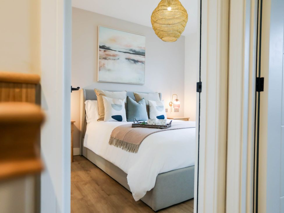 A bedroom with a bed and nightstand at Luxury 2 Bed Home w/ Spa-like Ensuites & Patio Hereford