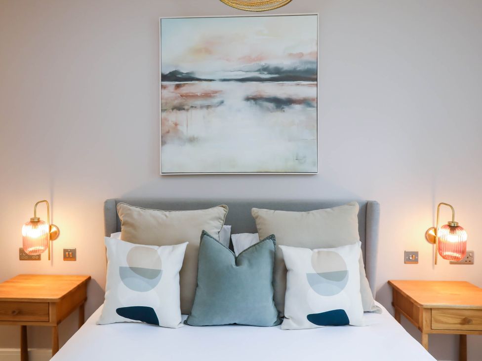 A bedroom with a bed and decorative pillows at Luxury 2 Bed Home w/ Spa-like Ensuites & Patio in Hereford