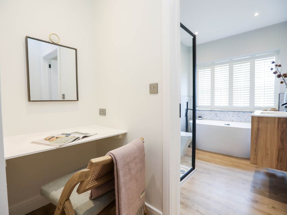 A bathroom with a desk and mirror at Luxury 2 Bed Home w/ Spa-like Ensuites & Patio in Hereford
