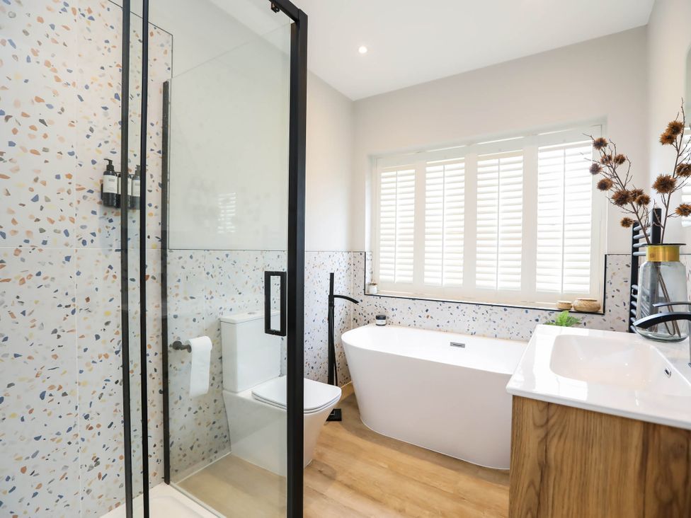 A bathroom with a shower, bathtub, toilet, and sink at Luxury 2 Bed Home w/ Spa-like Ensuites & Patio, Hereford