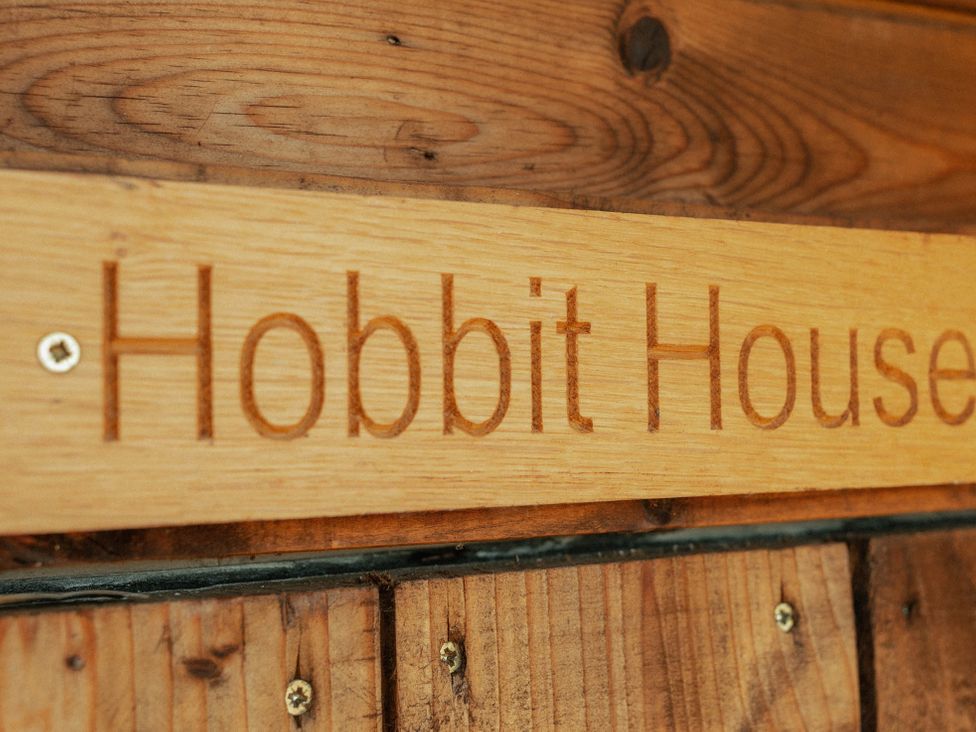 A wooden sign with Hobbit House text at Glamping at the Retreat Wiltshire Christian Malford