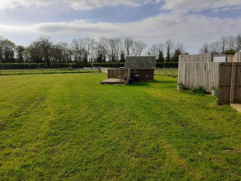 An outdoor area with grass and a small building at Glamping at the Retreat Wiltshire is rural bliss Christian Malford