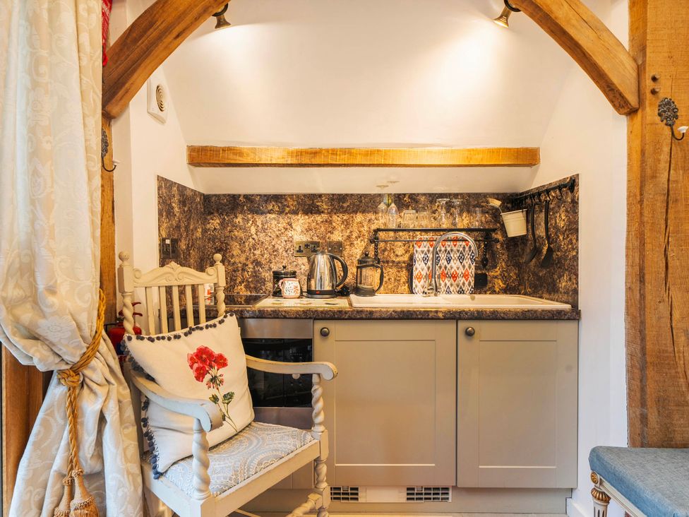 A kitchen area with a sink and a chair at Bramble Bank 'CartShed'-1 Bed Cottage-Sleeps 2 Henley-On-Thames