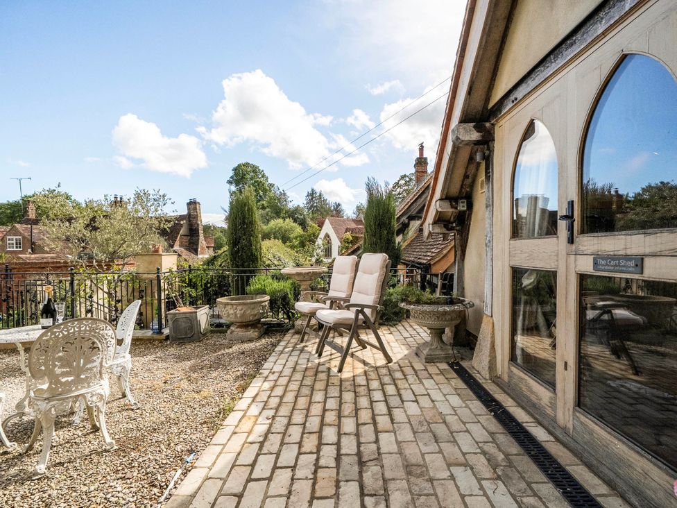 An outdoor terrace with chairs and a table at Bramble Bank 'CartShed'-1 Bed Cottage-Sleeps 2 Henley-On-Thames