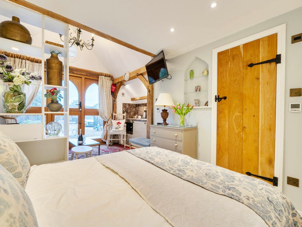 A bedroom with a bed and television at Bramble Bank 'CartShed'-1 Bed Cottage-Sleeps 2 Henley-On-Thames