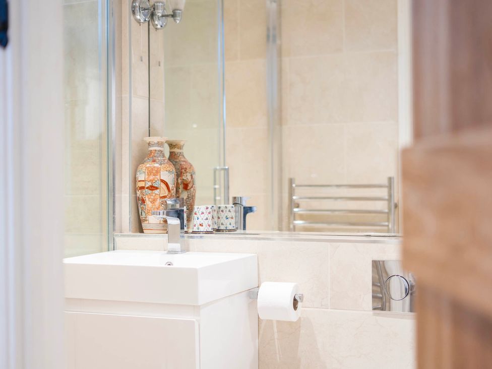 A bathroom featuring a sink, toilet, and decorative vases at Bramble Bank 'CartShed'-1 Bed Cottage-Sleeps 2 Henley-On-Thames