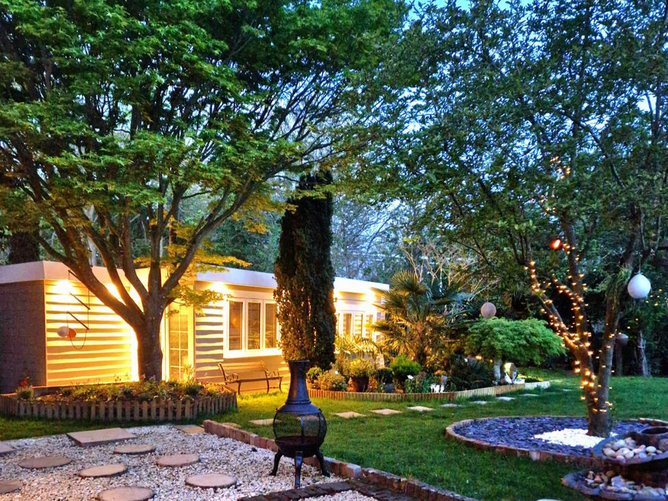 A garden with a house and trees at 1 Bed Cottage-Museum View-Garden-Free Parking, Weybridge, Surrey